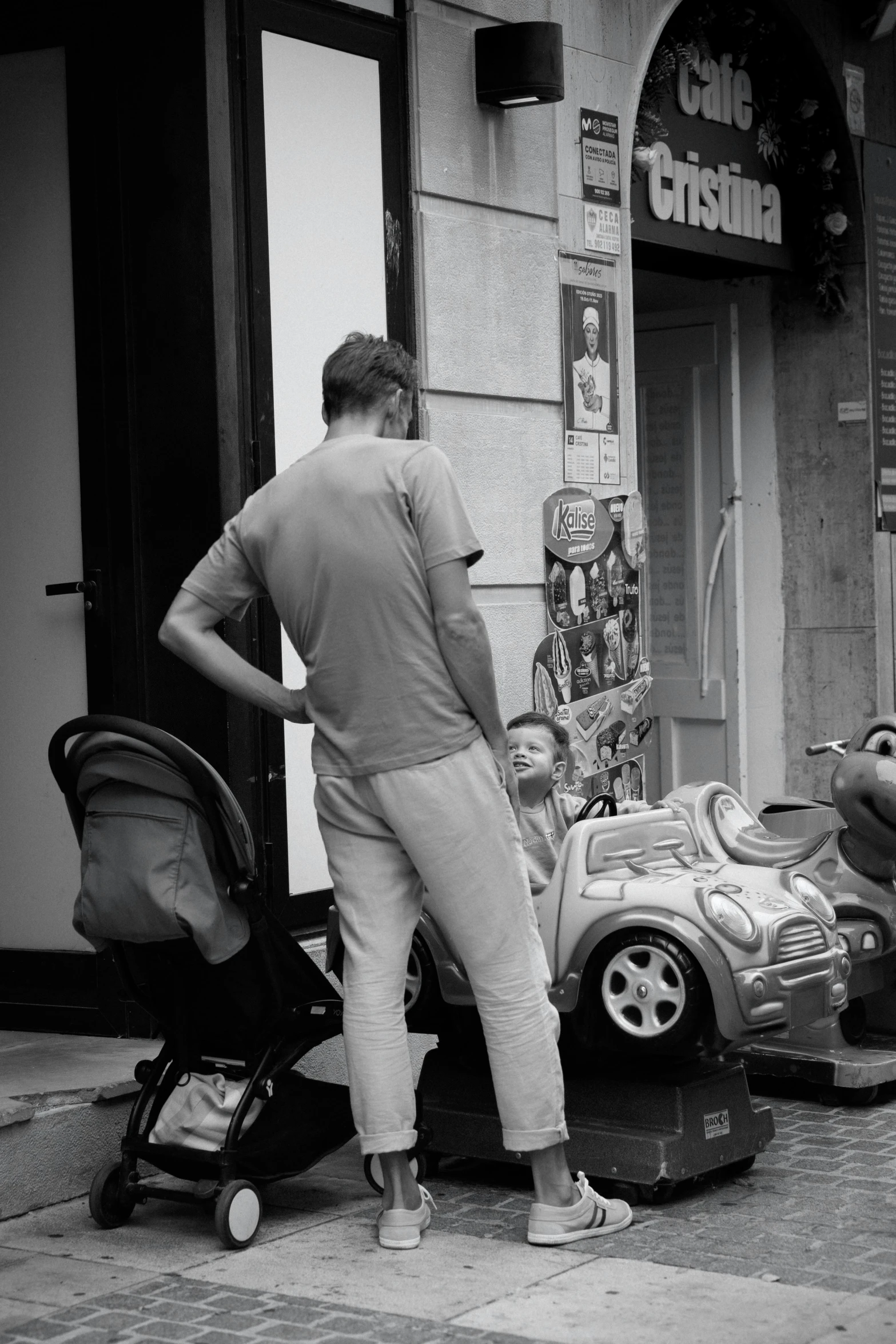 a man looking in the mirror on a car outside of a store