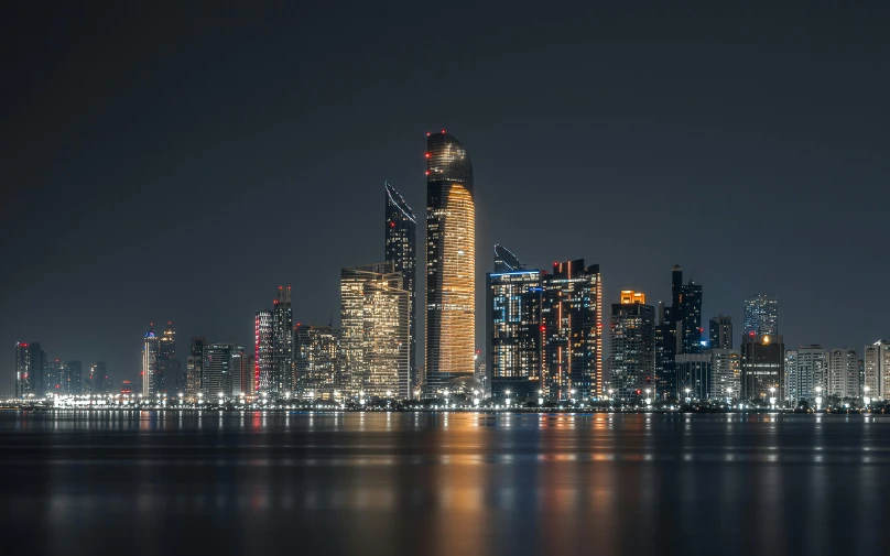 the night view of a city skyline, with many lit up buildings