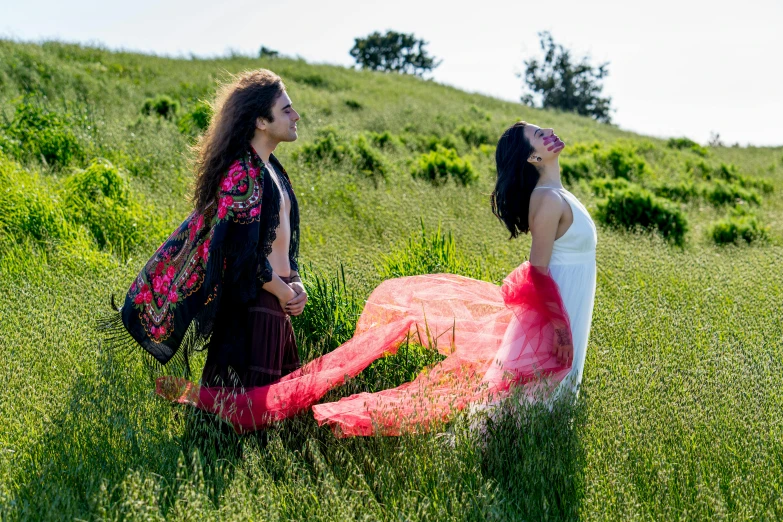 two women stand in the middle of a field