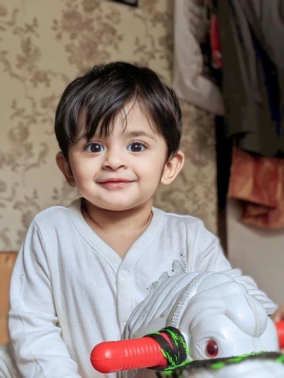 an adorable child smiling holding a pair of gloves