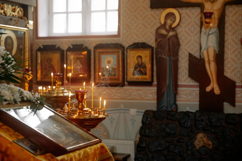 the altar with the candles lit is surrounded by wall paintings
