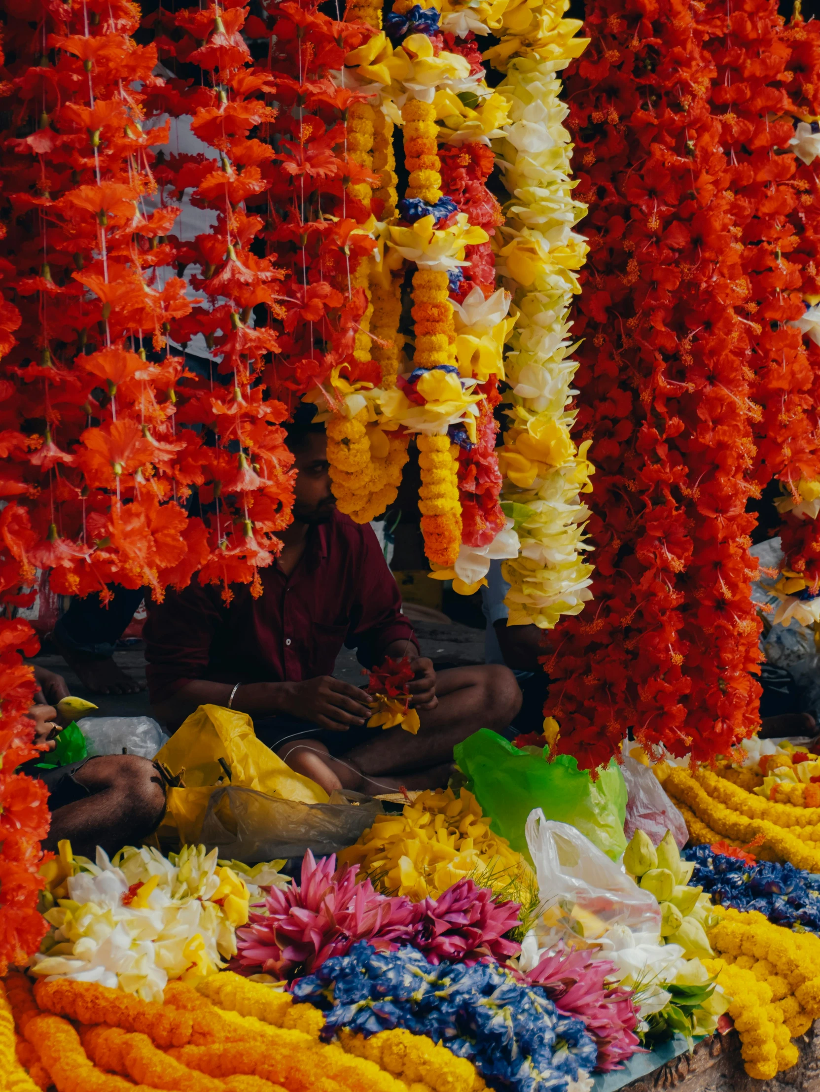 there is a woman sitting underneath colorful flowers