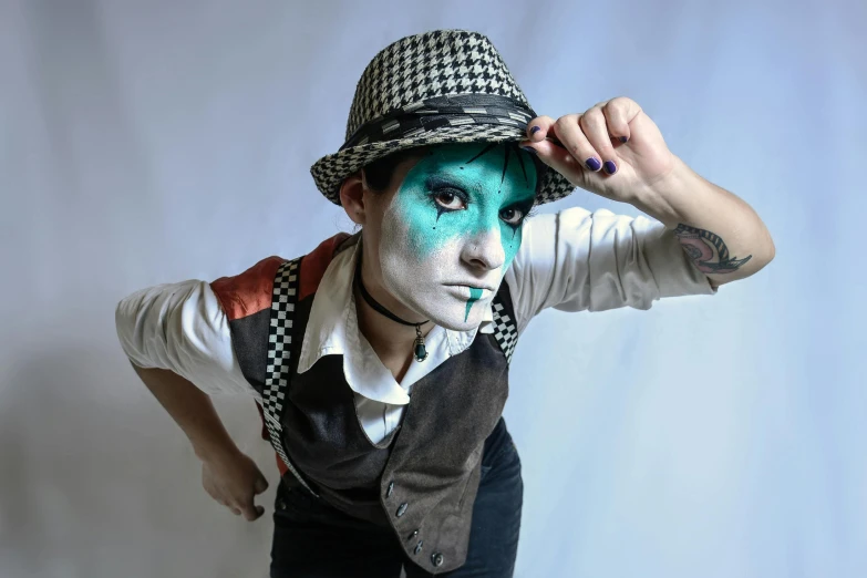 a man wearing blue and green makeup while posing