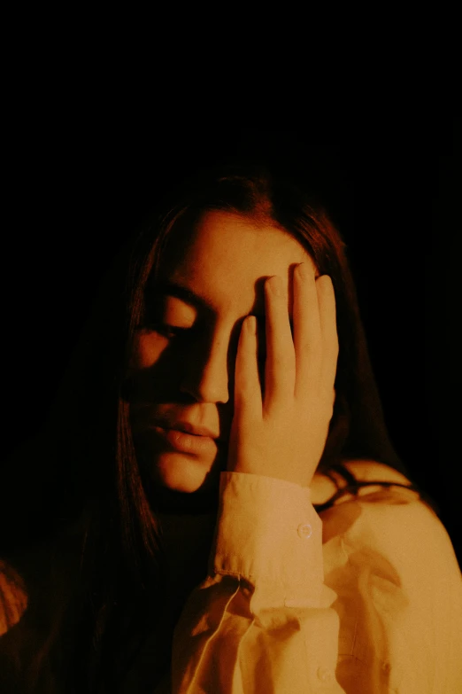 a woman holding her hand near her face with both hands