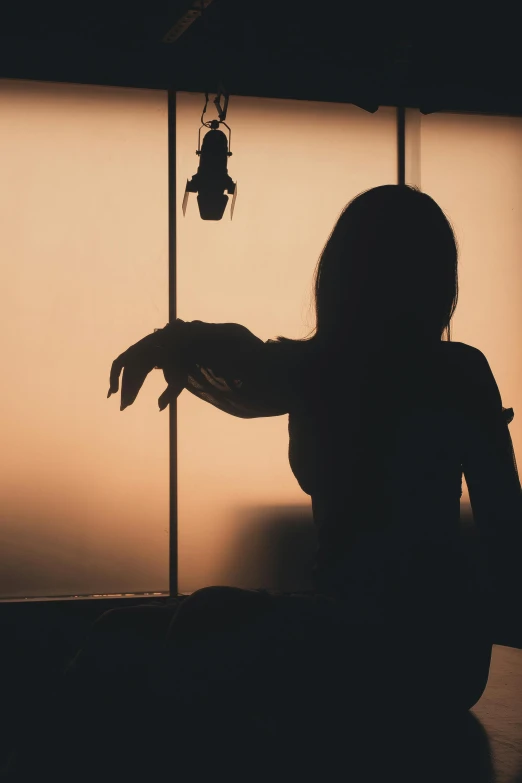 a silhouetted image of a person holding a bell