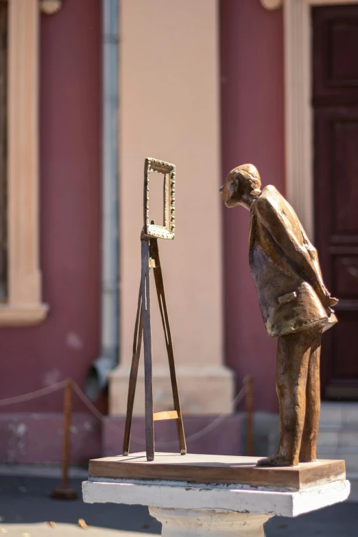 an old statue is looking at a picture