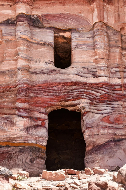 a rocky cliff has small stone holes with openings in it