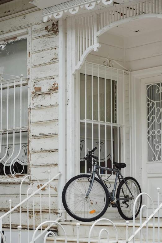 a bicycle that is parked on the front porch of an old house