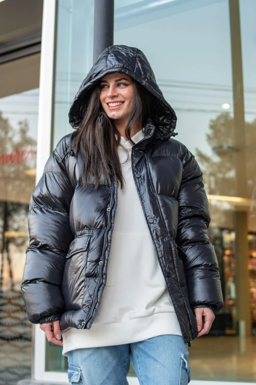 a woman in a black coat is walking down the street