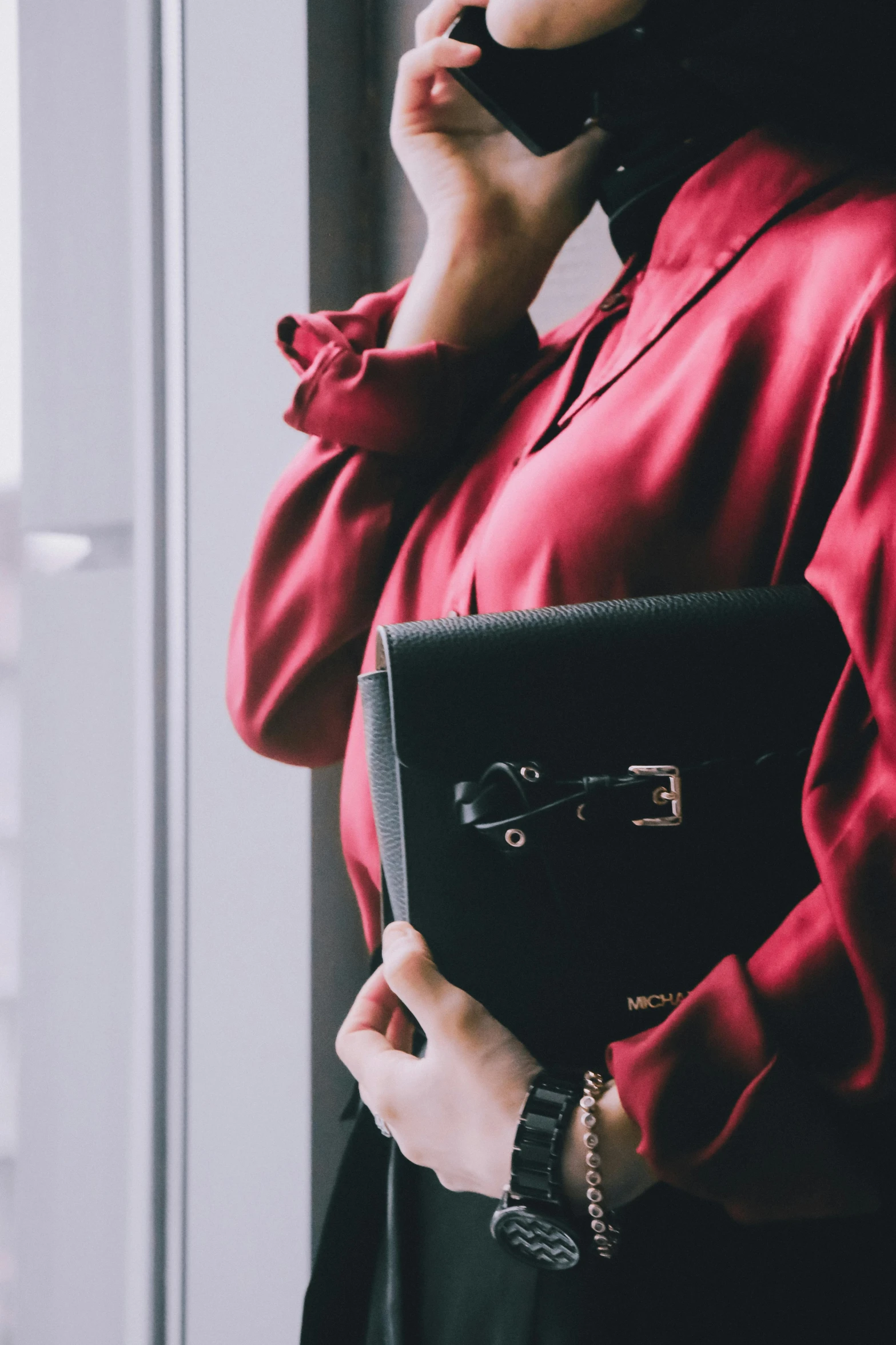 a woman with her purse and cellphone to her ear