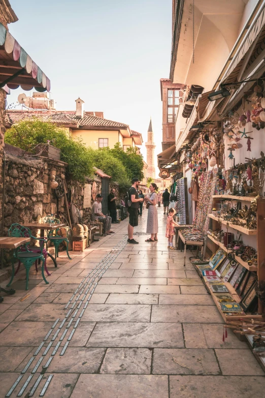 an alleyway with several vendors walking down the street