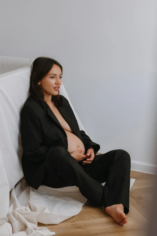 a woman is sitting down on the floor next to pillows