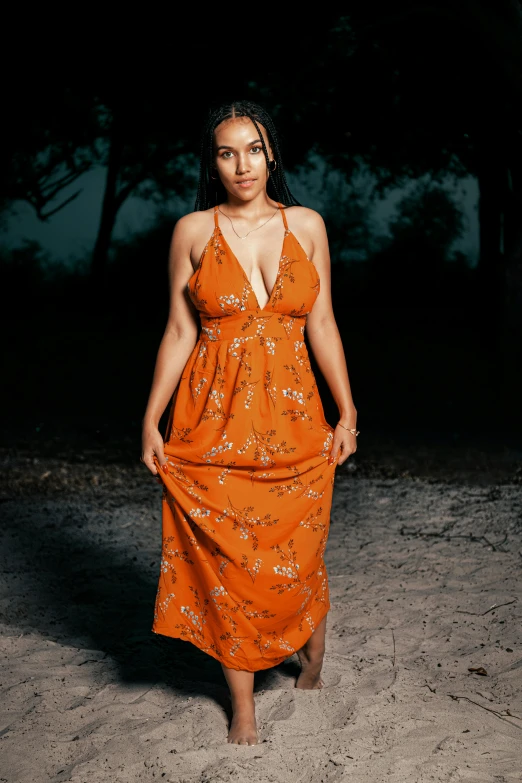 a girl is in an orange dress with flowers on it