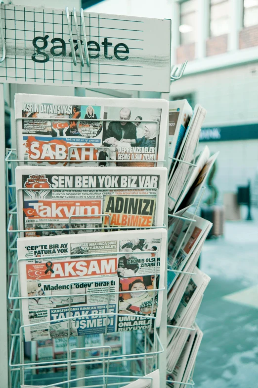 newspaper paper stand with magazines in front of it