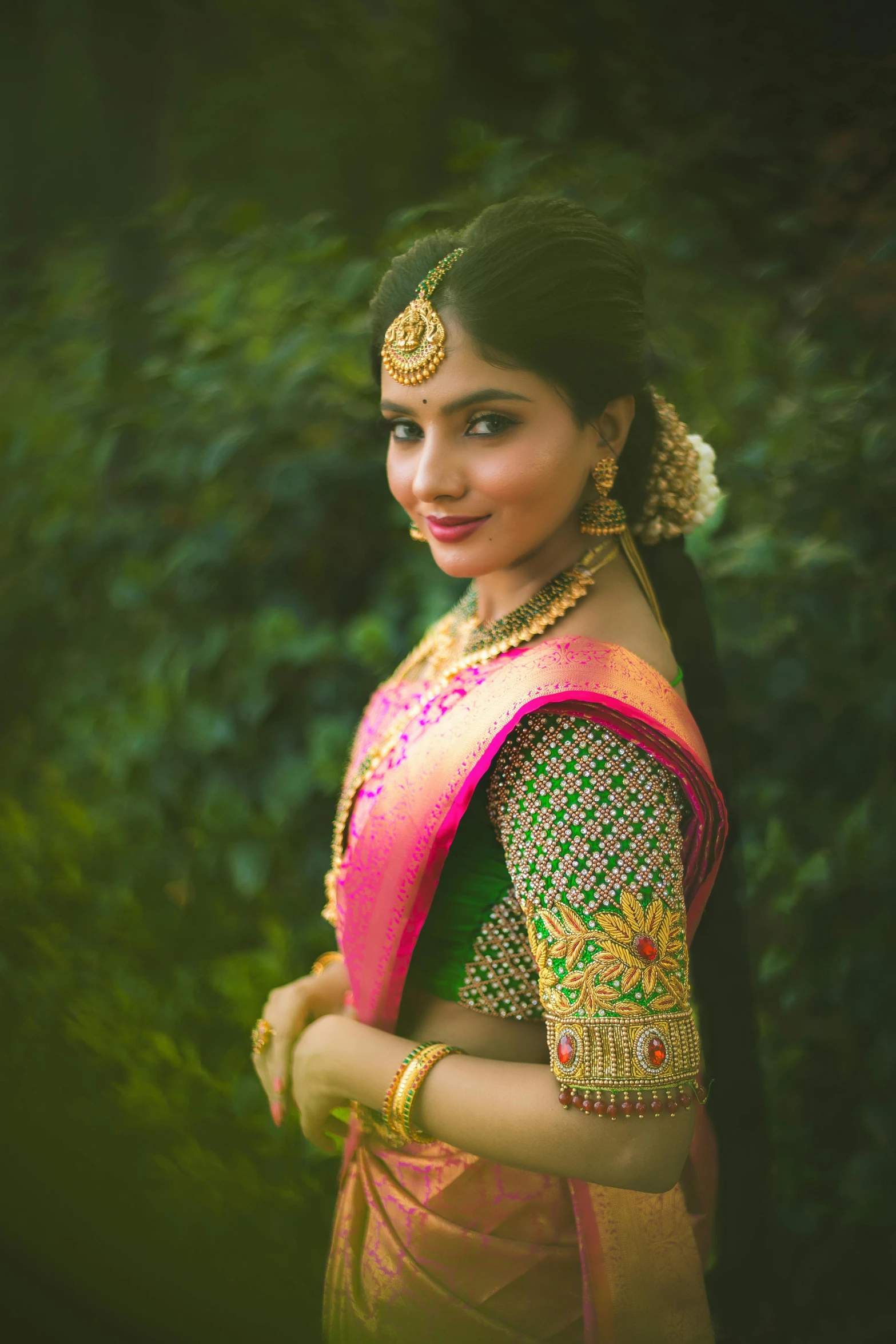 young woman dressed in green with golden jewelry and necklace