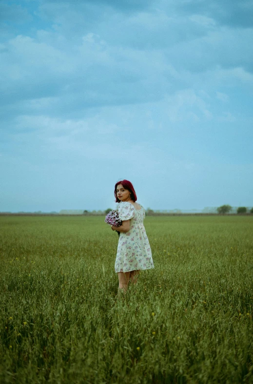 girl in a field of grass and looking to the side