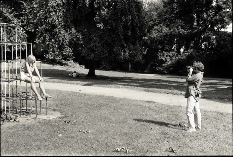 two people are playing in the park with a little boy on his back