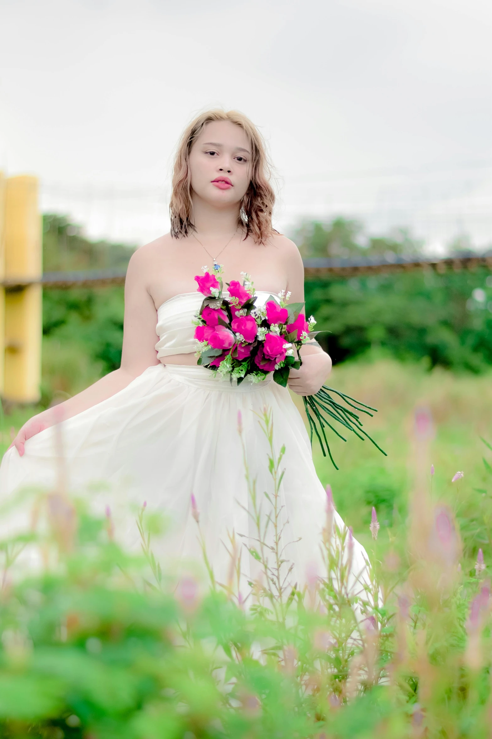 a woman wearing a dress holding a bouquet of flowers