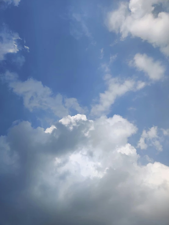 an airplane flies through the clouds on a sunny day