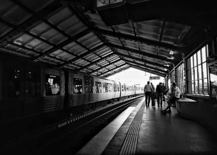 a couple of people walking down a train station platform