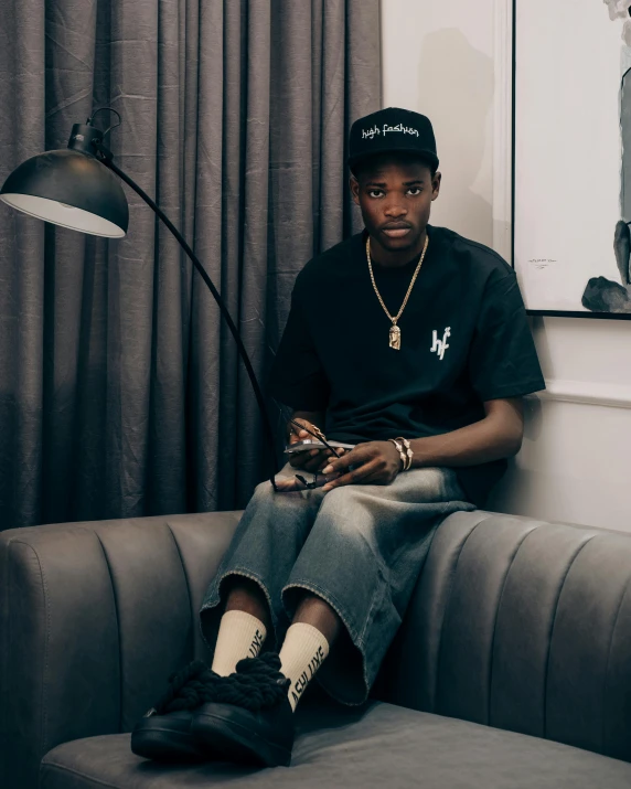 a man is sitting on a couch and checking his cell phone