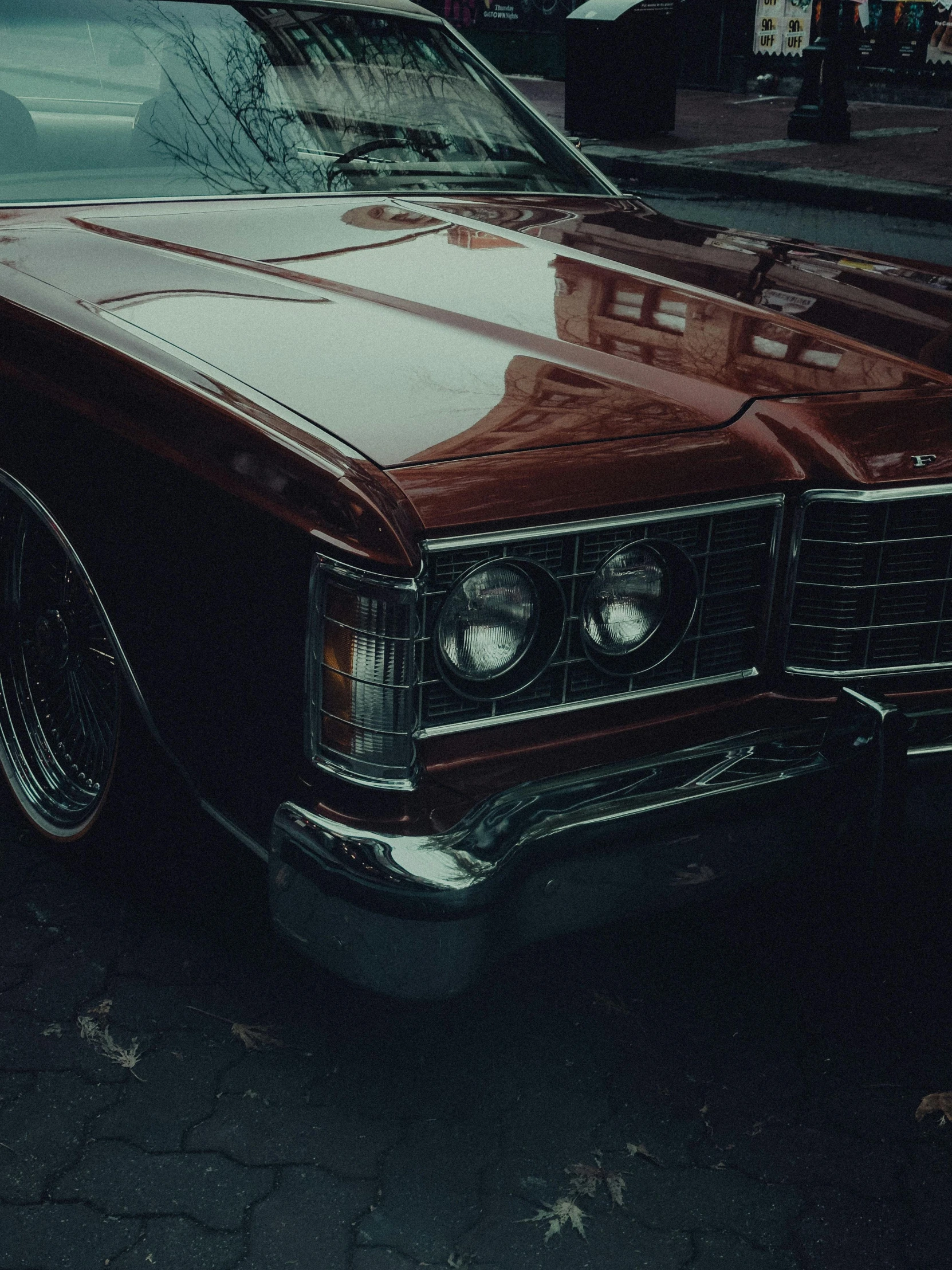 a dark colored car is sitting outside on the street