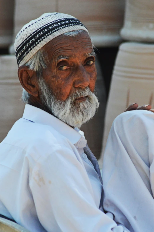 an elderly man with graying hair is wearing a hat