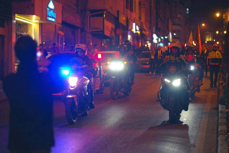 some bikers with police lights in the city at night