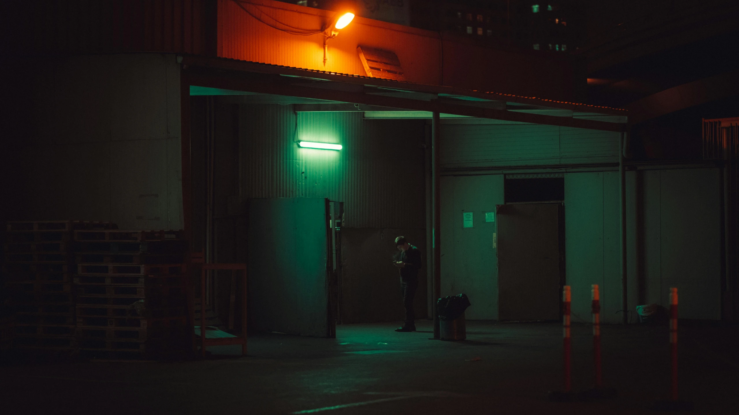 a small building with green light shining on the front