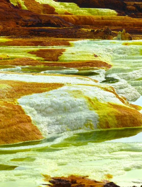 a river is surrounded by some colorful hills