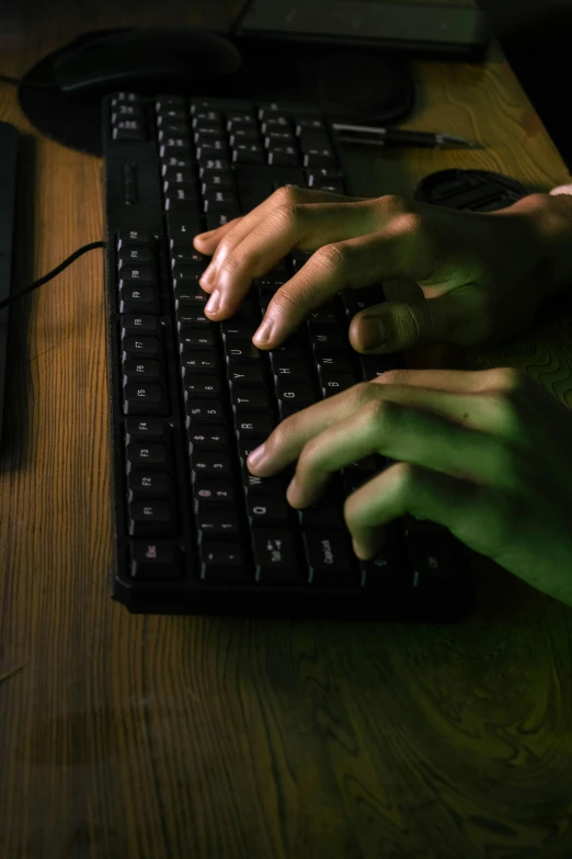 the hands of a person typing on a computer keyboard