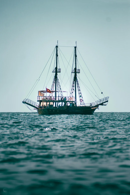 an old ship is in the middle of the ocean