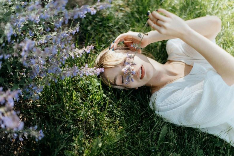 a girl is lying in the grass and has painted on her face