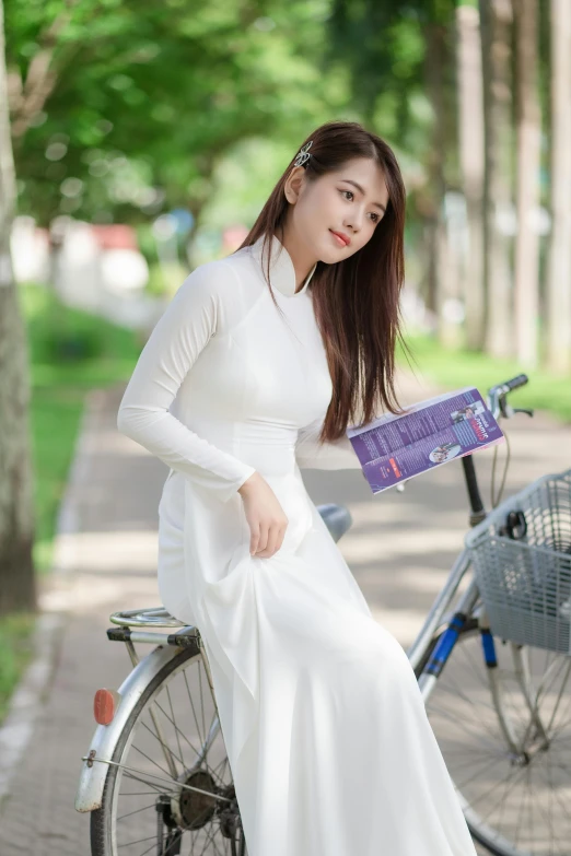 a woman sitting on a bike with a purple purse