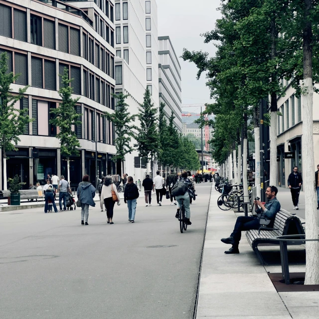 a group of people sitting on top of a bench on a street