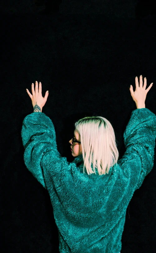 a woman with her hands up and looking into the sky