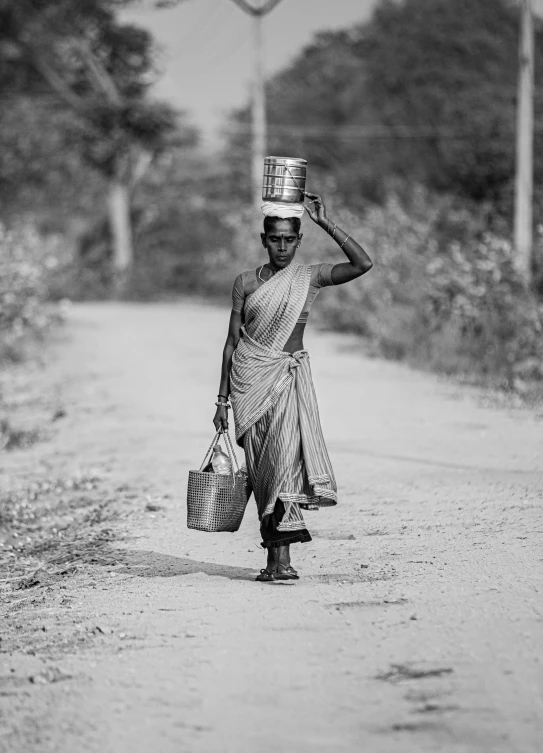 a woman walking down the road carrying bags