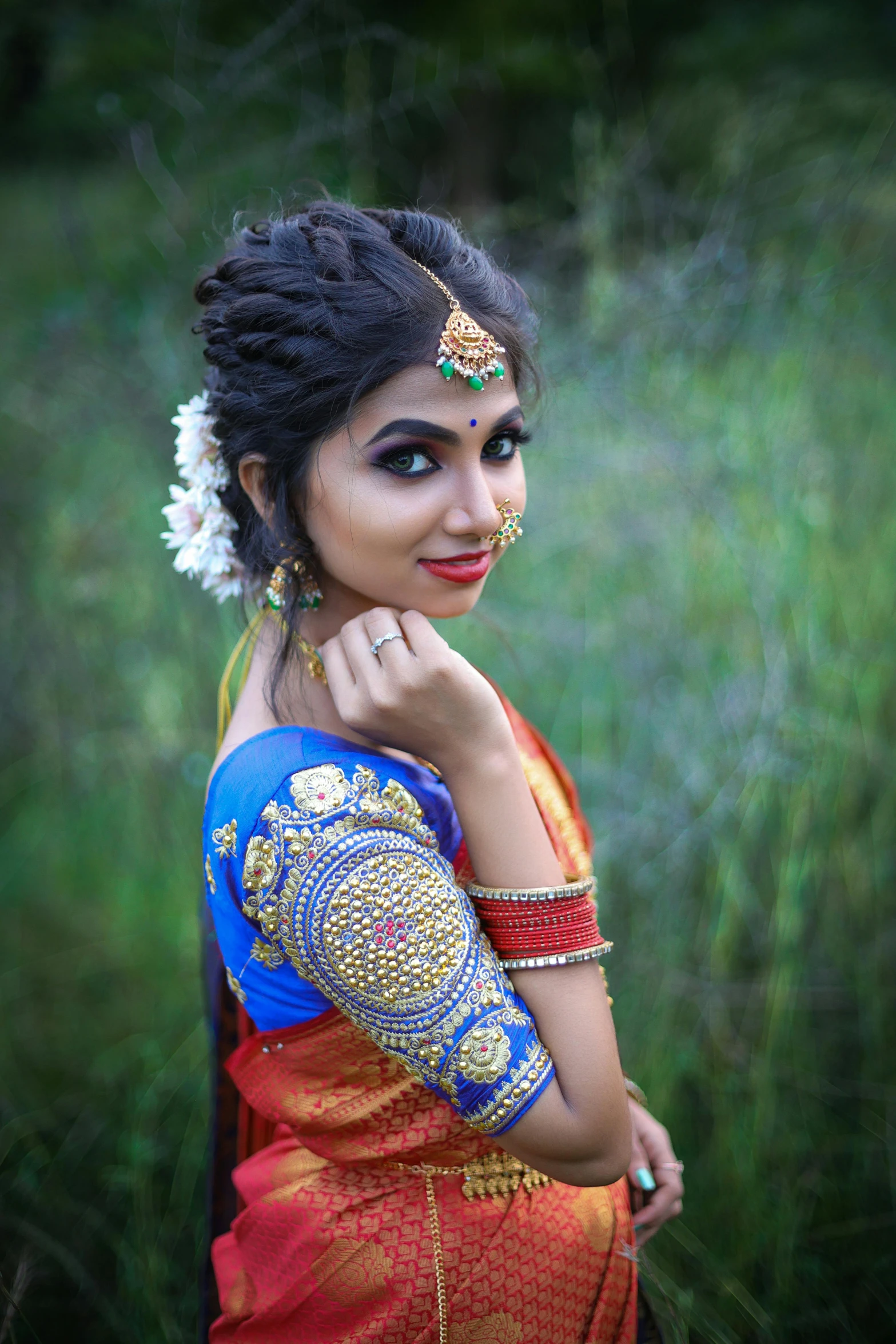 a woman in indian clothing poses for the camera