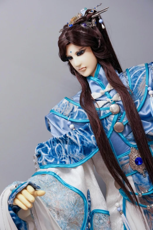 a dolls dressed in blue holds her hair in place