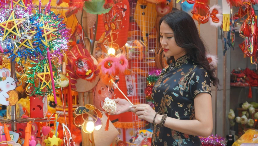 an asian woman selecting colorful items at an oriental store