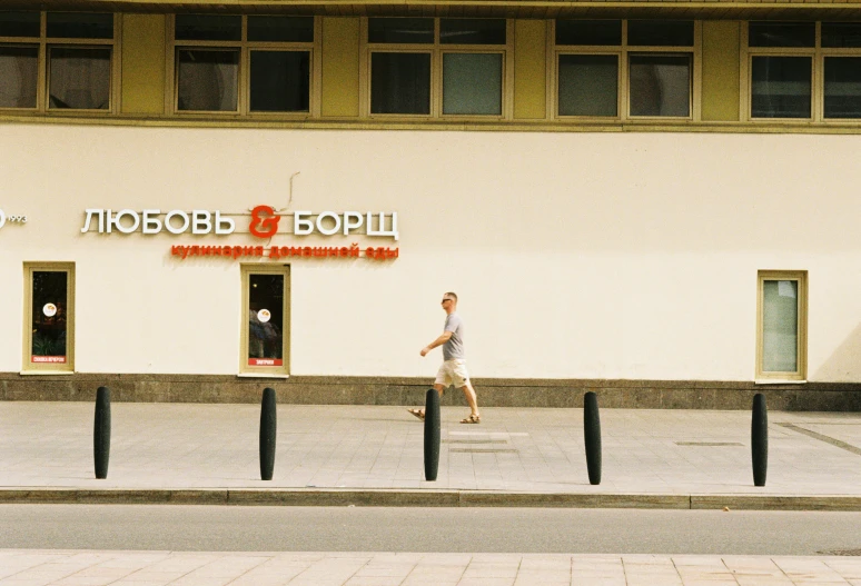 people walk on the sidewalk near a building