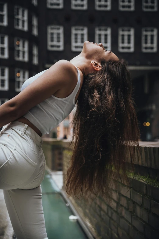 a woman leaning back with her head against the wall