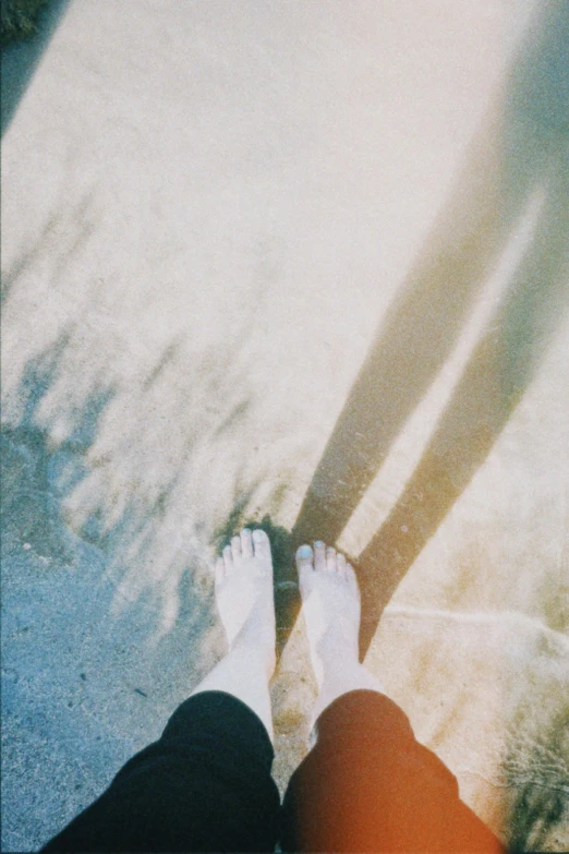 a person with their feet spread out on the sidewalk