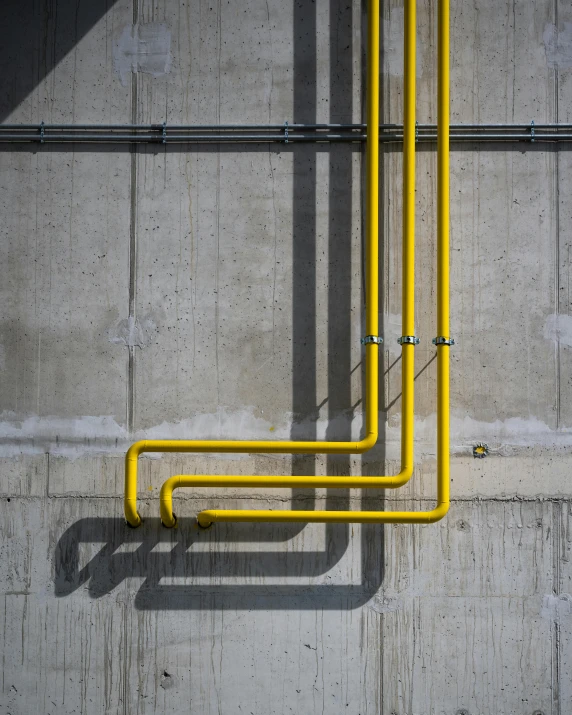 a yellow piping system on top of a concrete floor