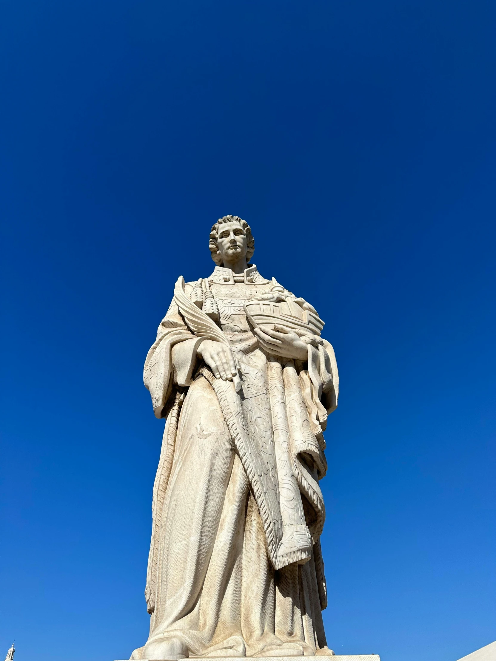 a tall white statue with a blue sky in the background