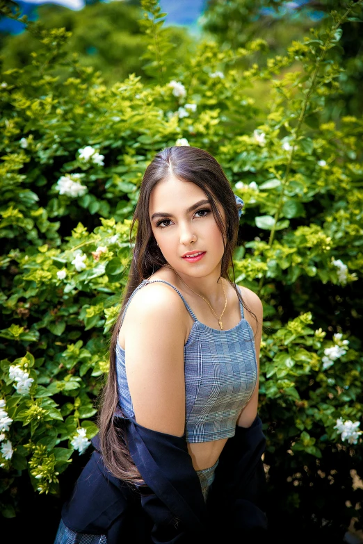 a girl in blue posing on green plants