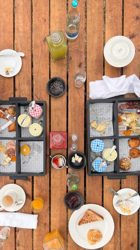 a picnic table is covered with plates and food