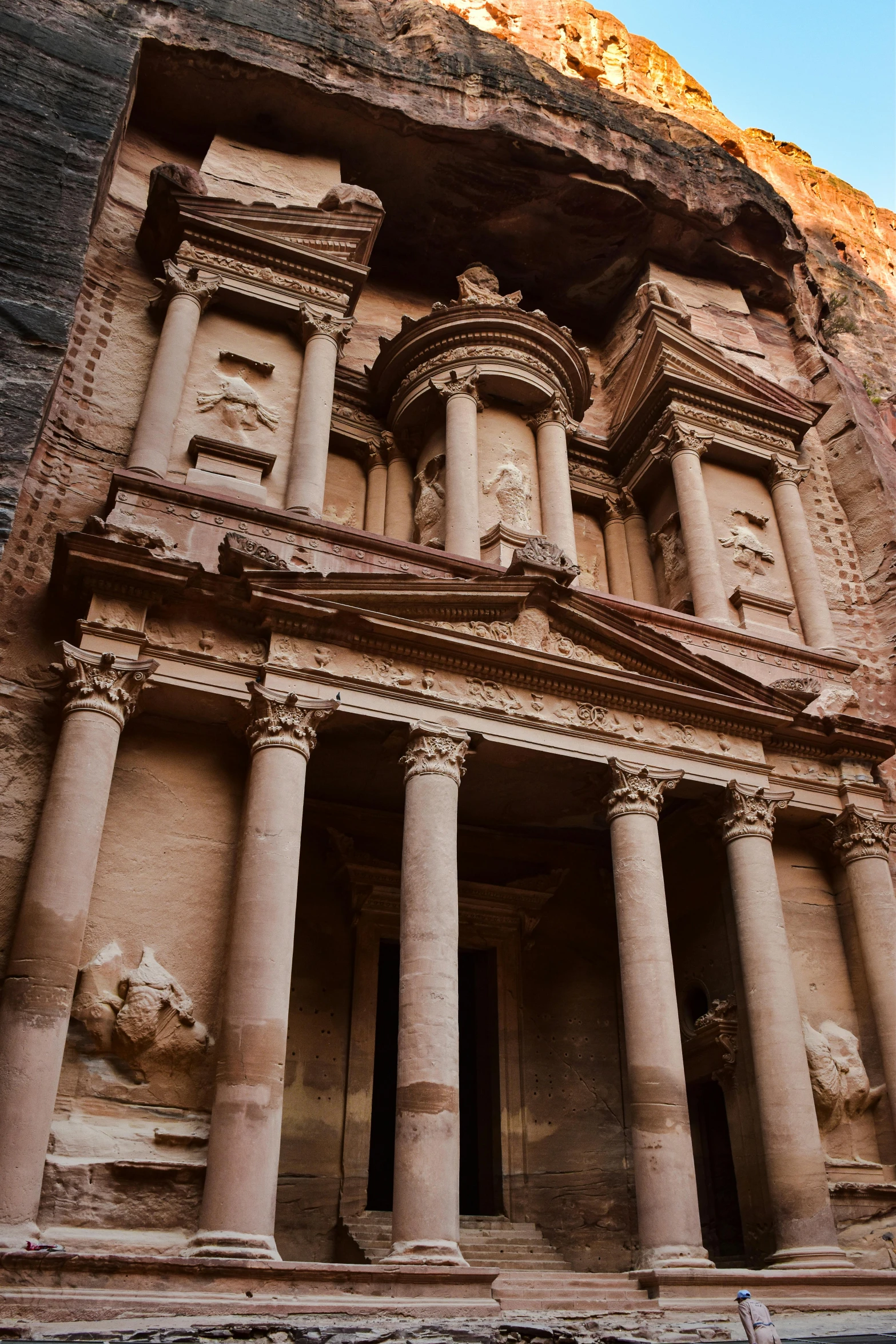 an ornate carved stone building near the mountains