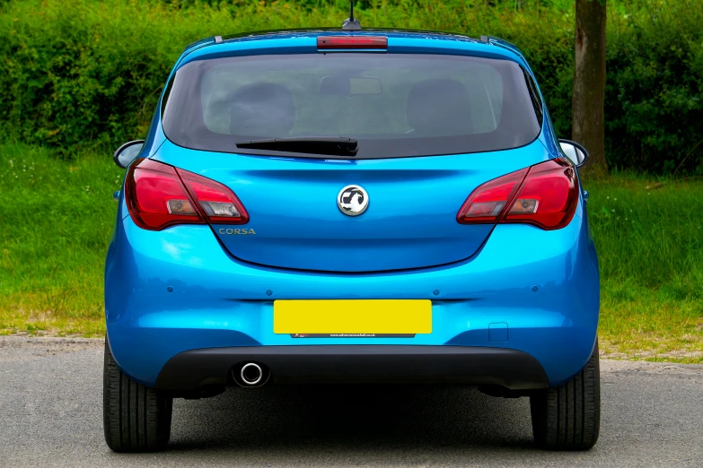 a blue opel is shown parked on the road