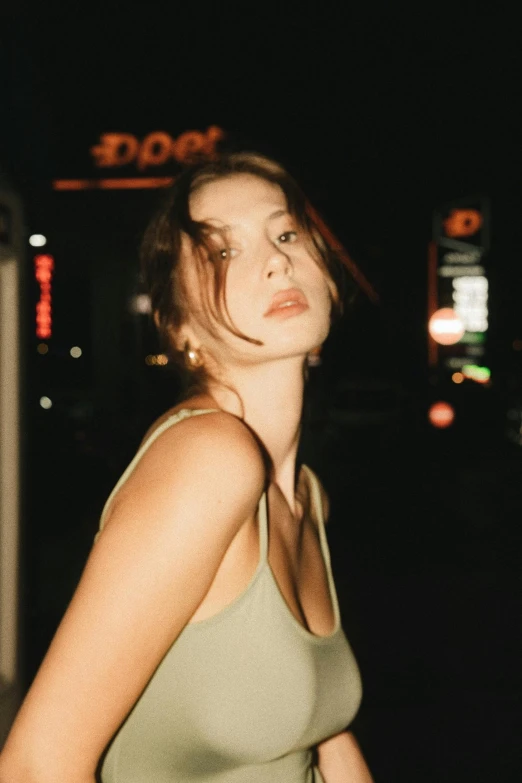 a young woman standing on the street at night